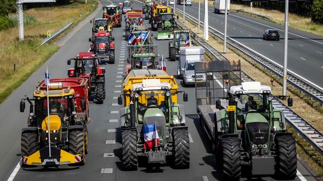 Dutch farmers drive their tractors on the A35 motorway in protest against the government's plan to cut nitrogen emissions. The farmers have wreaked havoc for weeks, dumping manure and garbage on highways, blockading supermarket warehouses with tractors and rallying noisily outside politicians' houses.