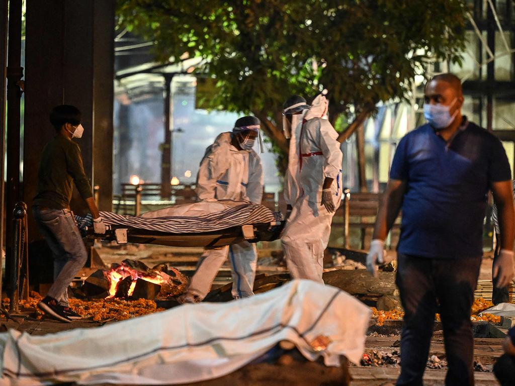 Relatives and staff carry a dead body of a coronavirus victim at Nigambodh Ghat Crematorium, on the banks of the Yamuna river in New Delhi. Picture: AFP