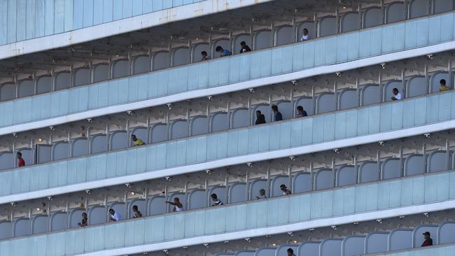 Passengers look on as the Ruby Princess docks at Port Kembla. Picture: AAP