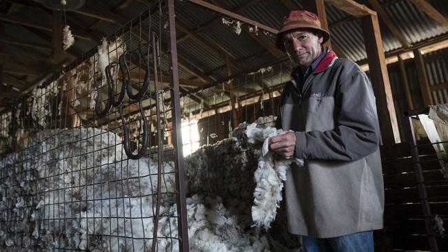 Greg Jerry inspects wool shorn early from his flock. Picture: Getty