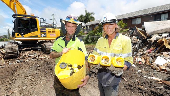 Workers Warren Bale (left) and Mark Jenson with containers of used syringes they found on site. Photo by Richard Gosling