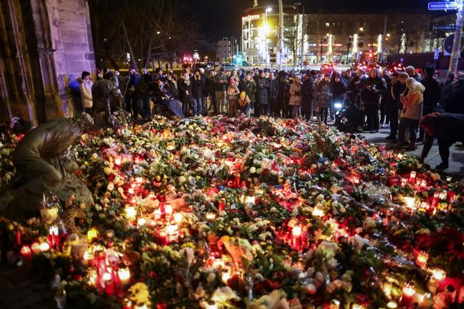 People lay flowers and place candles near the site of a car-ramming attack on a Christmas market in Magdeburg, eastern Germany