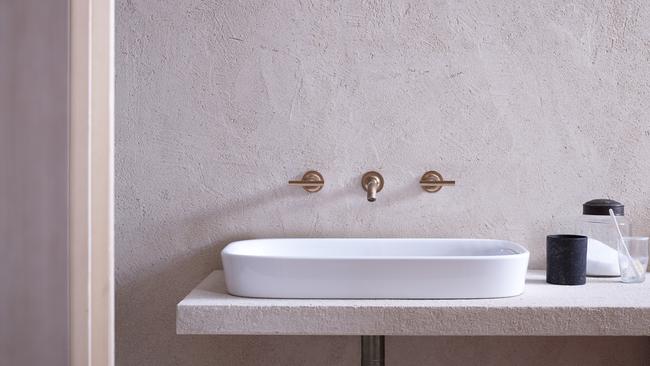 The combination of materials, including a ceramic basin from Kohler, brass-finished taps and rendered walls, create a sense of warmth.