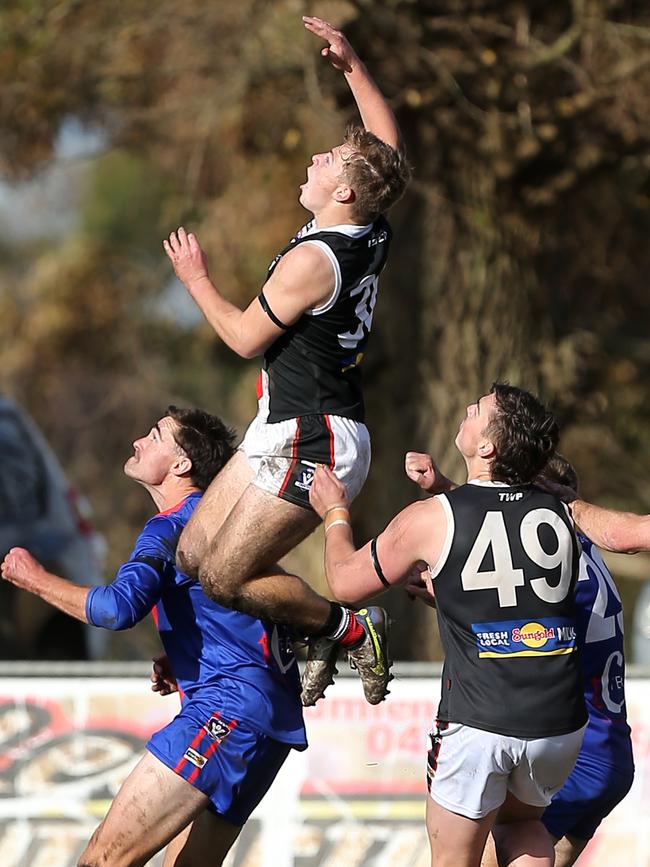 Terang-Mortlake’s Dylan Jones is used as a step ladder by Koroit’s Connor Byrne.