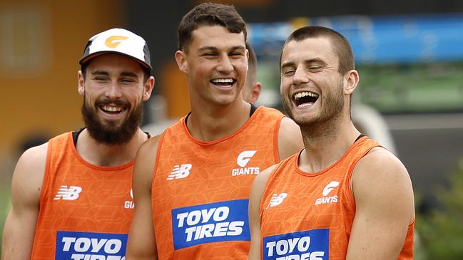 Lachie Ash, Finn Callaghan and Xavier O'Halloran share a laugh at training.