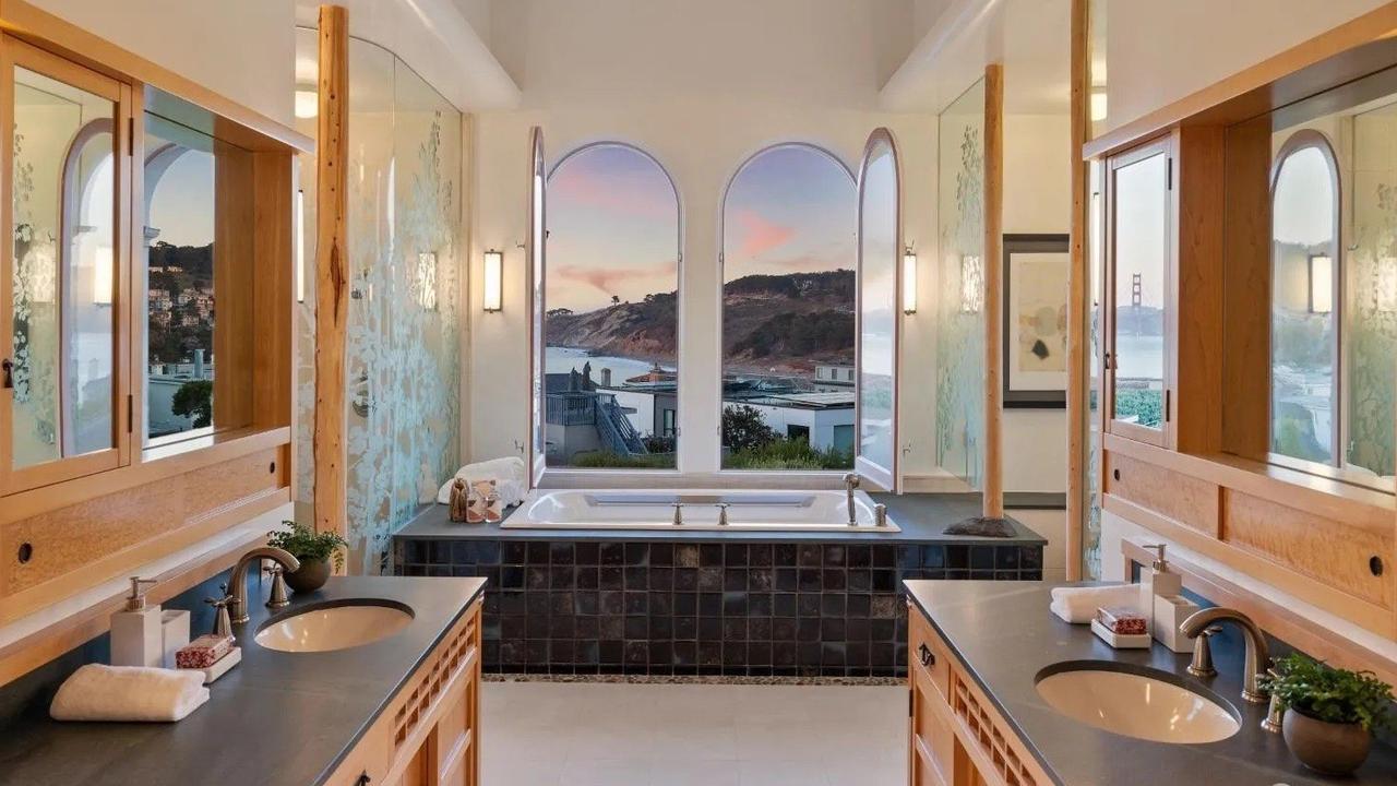 The primary suite, one of six bedrooms in the house, features a postcard-worthy view of the Golden Gate Bridge; custom vanities; a platform tub; and a walk-in shower. (Picture: Realtor.com)