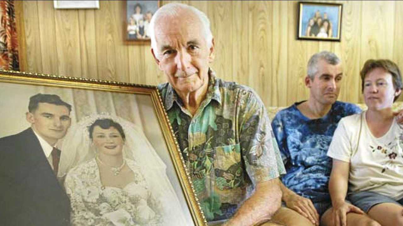 Jim Beyers holds a wedding photo of his wife Beryl. He is supported here by son Glenn and daughter-in-law Annette. Picture: Adam Wratten