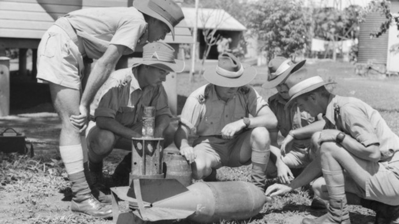 A police officer inspects a 60 kg Japanese incendiary bomb that failed to explode when dropped on Darwin in 1942. Photo: Australian War Memorial.