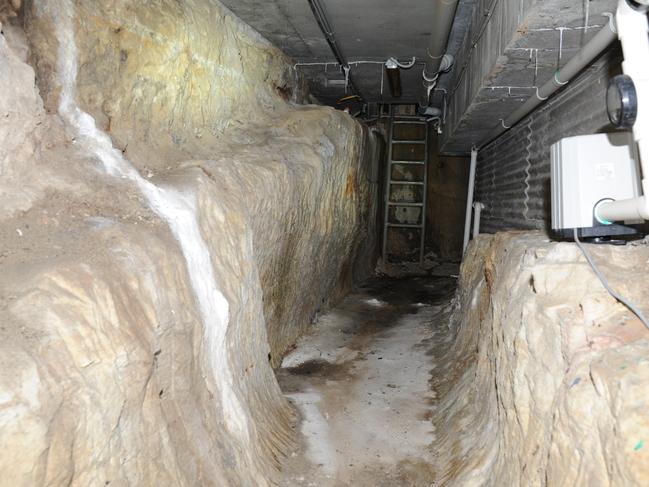 The ladder led to an underground tunnel that led down a set of wooden stairs to a toilet next to a door.