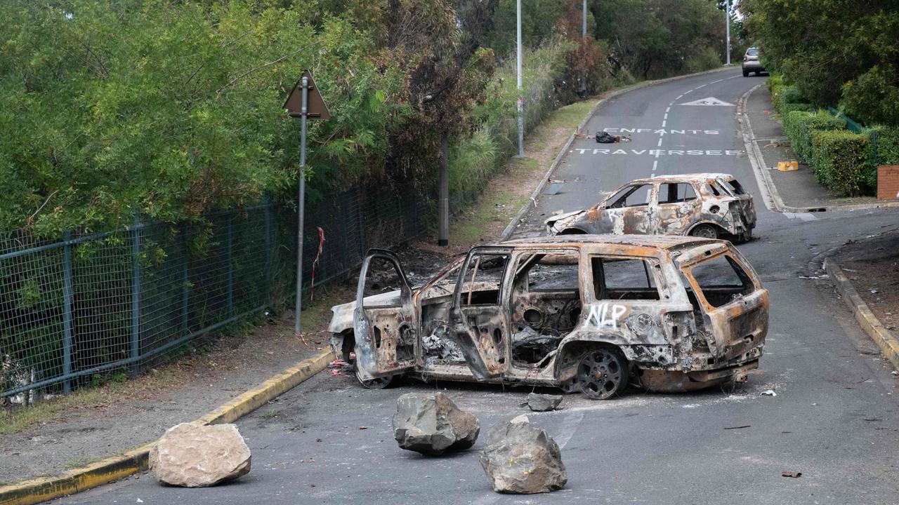 Vehicles and businesses have been torched by rioters. (Photo by Delphine Mayeur / AFP