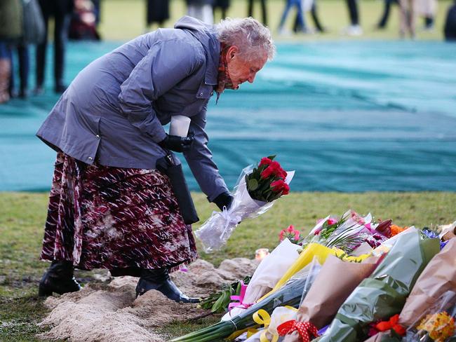 A mourner lays flowers in memory of Eurydice Dixon. Picture: Michael Dodge/Getty