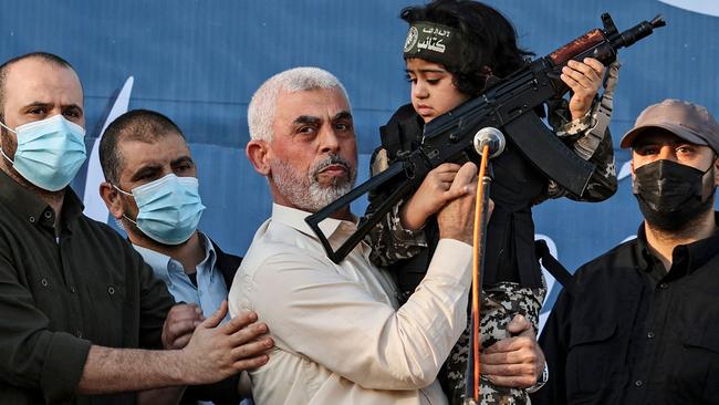 Yahya Sinwar holds the child of an Al-Qassam Brigades fighter, who was killed in fighting with Israel. Picture: AFP.