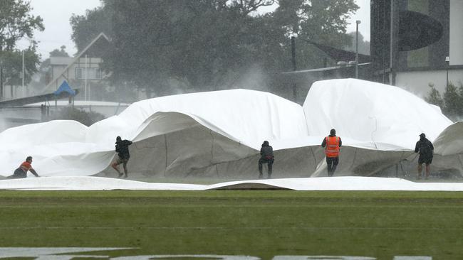 Grounds crew run out to put the covers on in Moe, Australia. (Photo by Darrian Traynor/Getty Images)