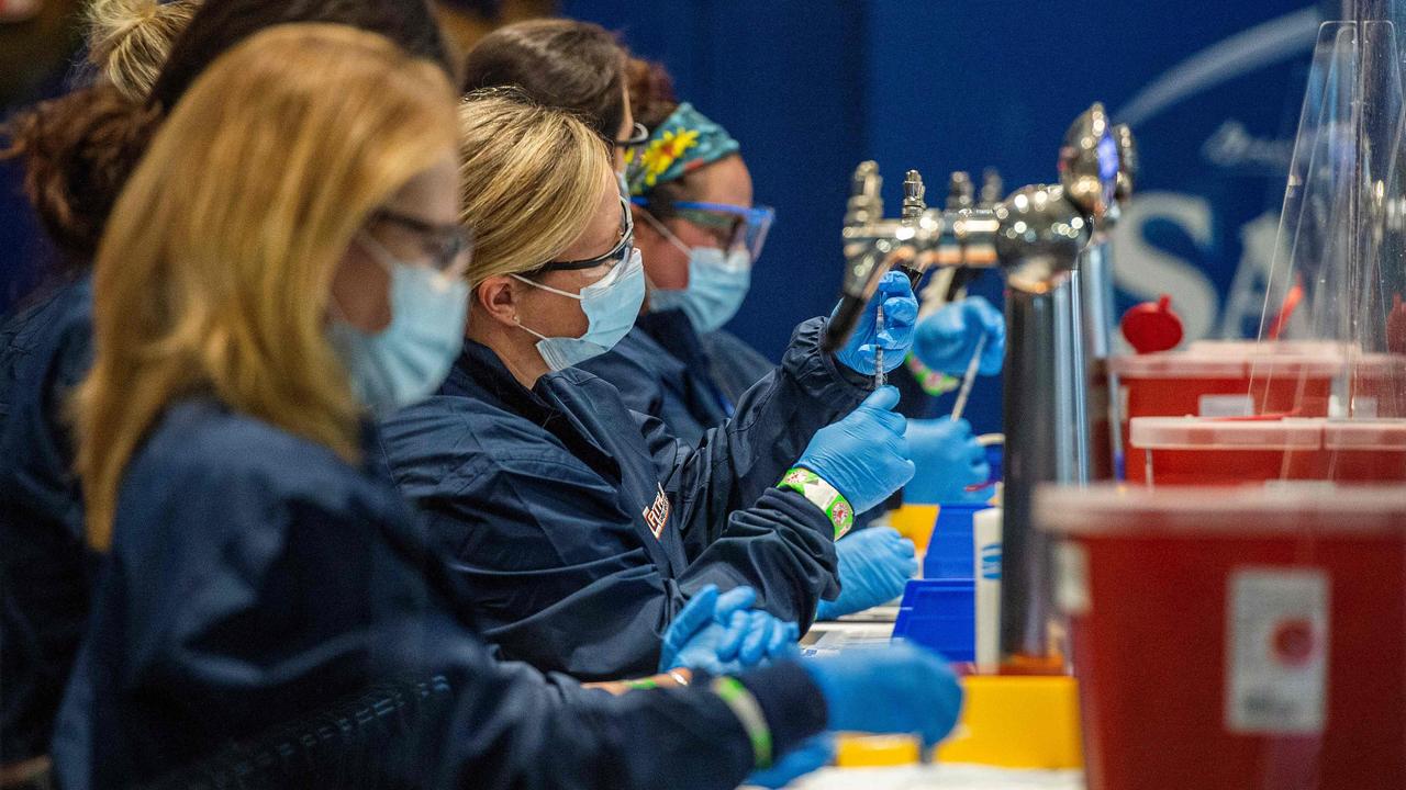 Medical staff workers prepare syringes with doses of Covid-19 vaccine while working behind beer taps at Fenway Park in Boston, Massachusetts. Picture: Joseph Prezioso/AFP