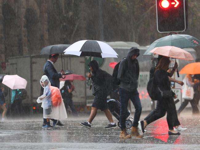 Daily Telegraph March 27/3/23. Commuters caught out in the occasional heavy showers in the City .picture John Grainger