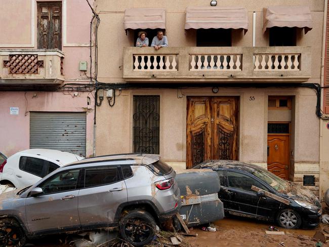 Residents look from their balcony above piled up cars following deadly flash floods in La Torre, south of Valencia, eastern Spain. Picture: AFP