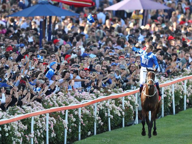 2017 Moonee Valley Cox Plate Day, at Moonee Valley Racecourse. Hugh Bowman celebrates on Winx after her win, and throws his helmet into the crowd. Picture: Alex Coppel.