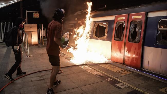 A pro-democracy protester sets fire to a subway train during a demonstration at the Chinese University of Hong Kong early on Wednesday morning. Picture: Getty Images