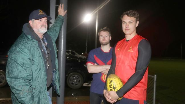 Flinders Park Football Club chairman John Cousins with players Jake Macro and Lachlan Fairly … the club is one of dozens targeted by thieves this winter sports season, seeking copper from oval lights, costing it thousands of dollars. Picture Dean Martin.