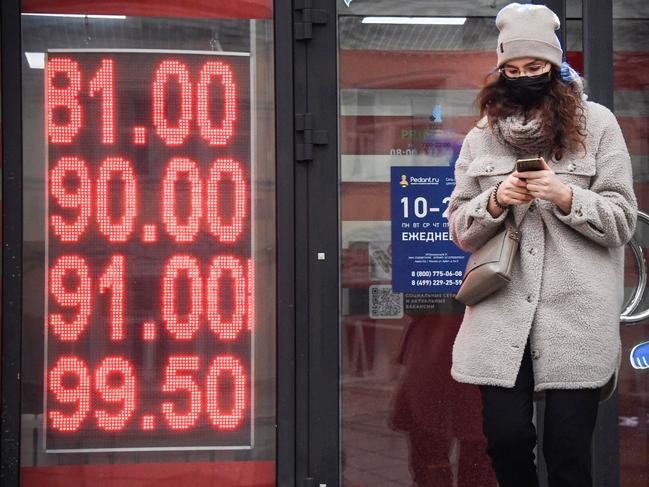 A woman walks past a currency exchange office in central Moscow on February 24, 2022. - Russia's central bank said Thursday in would intervene as the ruble tumbled to a record low and the Moscow Stock Exchange reopened down 14 percent after Moscow launched a military attack on Ukraine, as Russian President Vladimir Putin announced a military operation in Ukraine on Thursday with explosions heard soon after across the country and its foreign minister warning a "full-scale invasion" was underway. (Photo by Alexander NEMENOV / AFP)