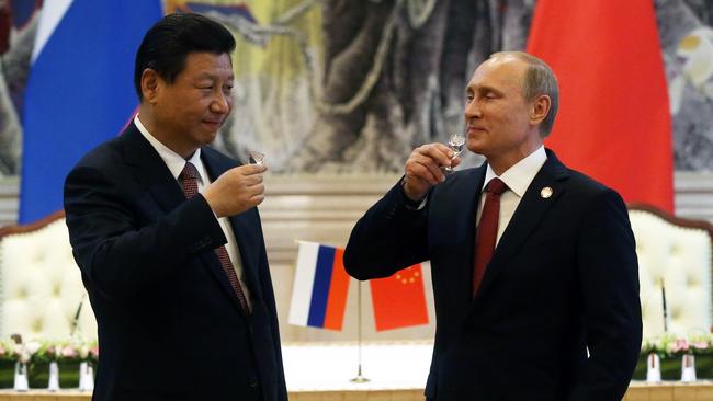 President of Russia Vladimir Putin and Chinese President Xi Jinping toast with vodka during a signing ceremony in 2014. (Photo by Sasha Mordovets/Getty Images)