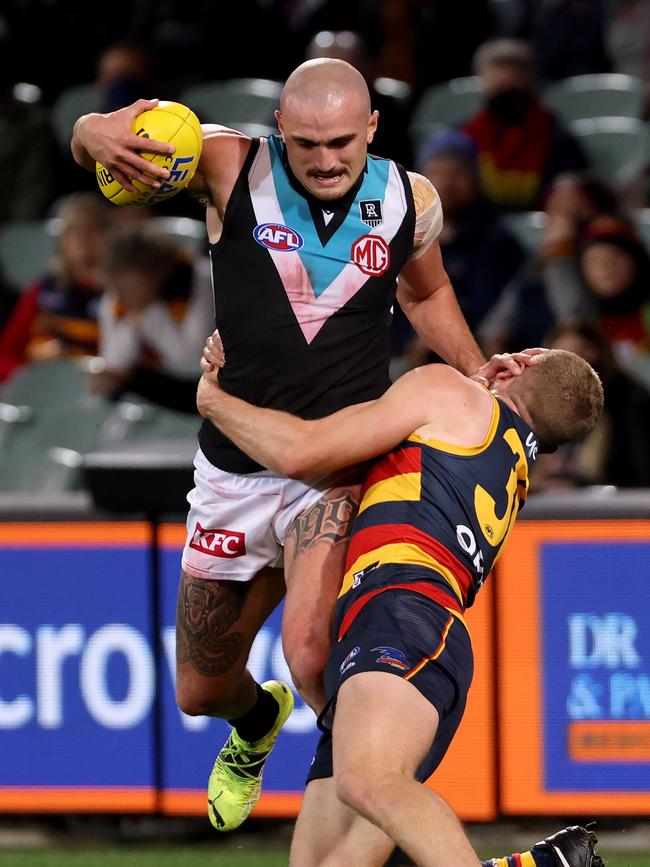 Sam Powell-Pepper tries to shake out of an Andrew McPherson tackle.