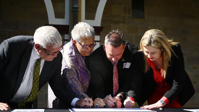 Queensland Premier Annastacia Palaszczuk, Minister for Aboriginal and Torres Strait Islander Partnerships Craig Crawford, Treaty Advancement Committee Co-Chair Dr Jackie Huggins and fellow Co-Chair Mick Gooda sign the Statement of Commitment to the Path to Treaty between the state and First Nations people, at Parliament House in Brisbane last year.