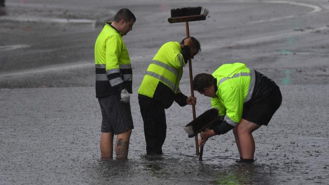 Council workers clear a drain on Railway Terrace in Lewisham this morning. Picture: AAP