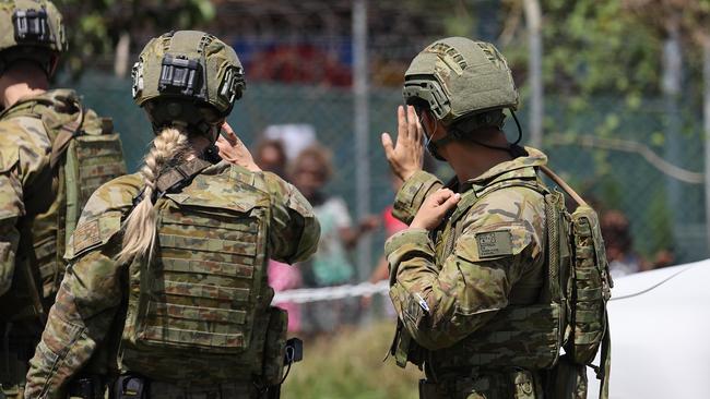 Australian soldiers wave to children in Honiara as they work to restore order. Picture: Gary Ramage