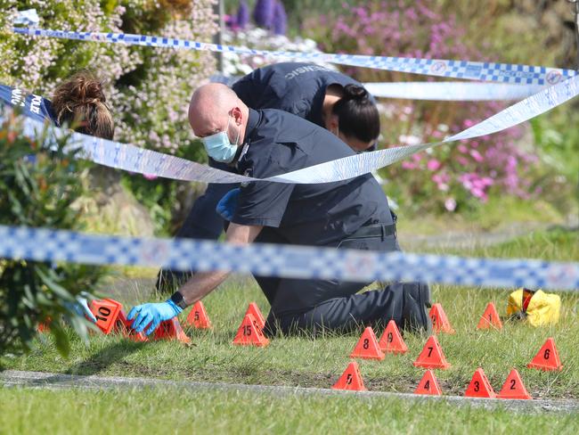 Forensic police mark out the bullet casings. Picture: David Crosling