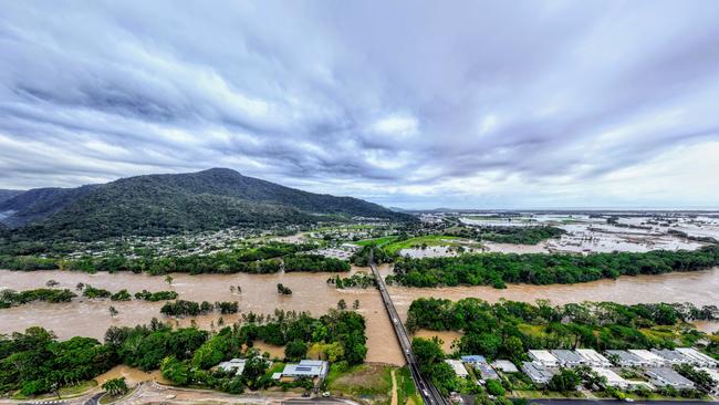 The Barron River in Cairns, far north Queensland, has reached a record flood peak, with roads closed and homes flooded in the catchment area.