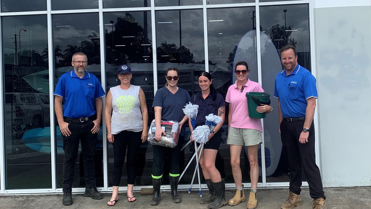 Sunshine Mitre 10's Steve Miatt (left) and Dean Chandler (right) helping Gympie Cats AFL members collect cleaning gear for recovery.