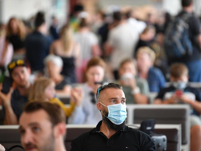 People are seen waiting for flights at Adelaide Airport after new border restrictions came into place. Picture: NCA NewsWire / David Mariuz