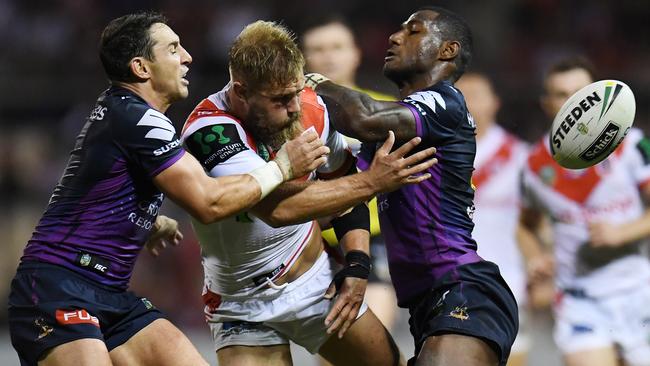 Jake de Belin of the Dragons is tackled by Billy Slater and Suliasi Vunivalu of the Storm last year. Photo: AAP