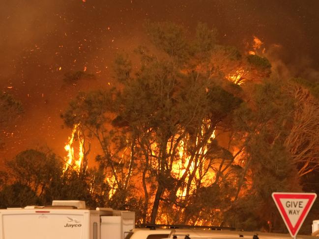 Bushfire arrives into the township of Malua Bay NSW, just south of Batemans Bay. Fires burning next to the beach on NYE.  Picture: Alex Coppel.