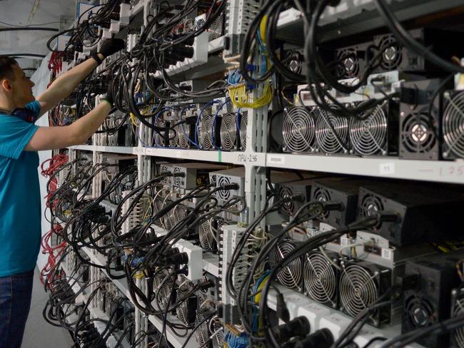 An employee inspects machines for the production of bitcoins and lightcoins at the "CryptoJuniversóe" mining centre during a presentation of the centre for the crypto currency in Kirishi on August 20, 2018. - A Russian company opened on August 20, 2018 what it said was the country's largest cryptocurrency mining unit, in a former Soviet fertilizer-producing laboratory. The opening comes as Russian authorities seek to regulate the booming cryptocurrency sector. Russia is in third place after China and the United States in the ranks of cryptocurrency-producing nations since 2015, according to a study published at the end of last year by Ernst & Young. (Photo by OLGA MALTSEVA / AFP)