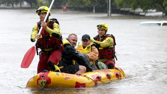 Adin Richardson and Karina Handall are rescued from their house in Milton on Sunday. Picture: Steve Pohlner