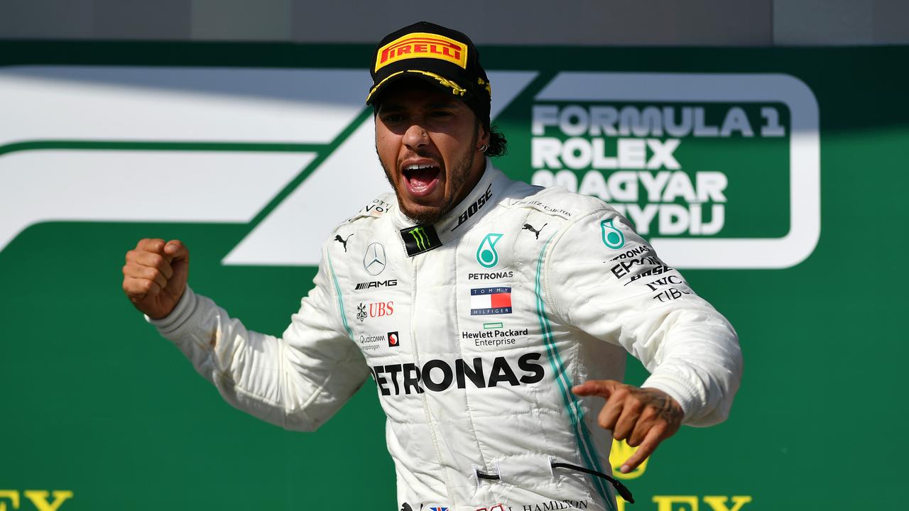 Race winner Hamilton celebrates on the podium at the Hungaroring.