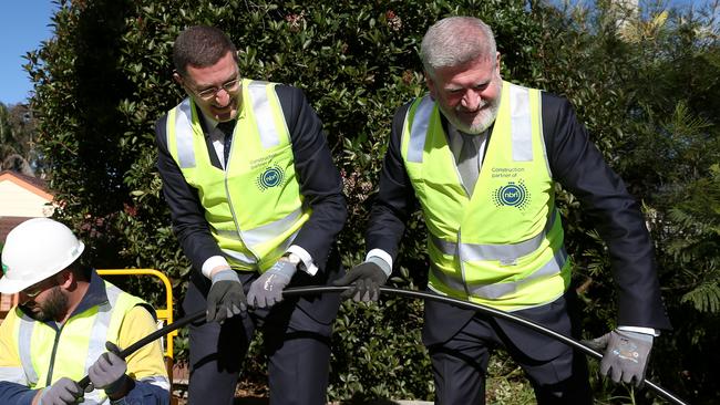 Federal Minister for Communications and Arts, Senator Mitch Fifield (r) installs NBN cable with Berowra federal Liberal MP Julian Leeser. Picture: AAP Image/Ashley Feder