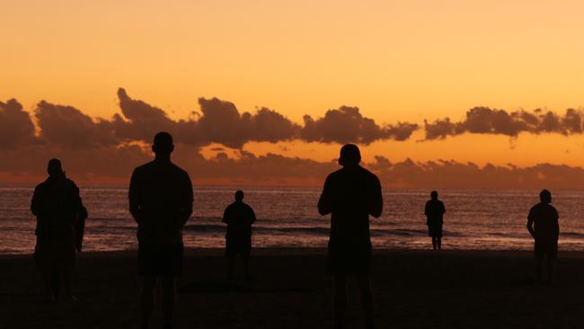 GOLD COAST, AUSTRALIA - APRIL 25: People watch the sunrise on Currumbin Beach to commemorate Anzac Day on April 25, 2020 in Gold Coast, Australia. Traditional Anzac Day ceremonies have been cancelled due to the global COVID-19 pandemic and subsequent restrictions on gatherings of people. Anzac day is a national holiday in Australia, traditionally marked by a dawn service held during the time of the original Gallipoli landing and commemorated with ceremonies and parades throughout the day, however with social distancing measures in place because of coronavirus (COVID-19), Australians this year are observing the day differently. Anzac Day commemorates the day the Australian and New Zealand Army Corp (ANZAC) landed on the shores of Gallipoli on April 25, 1915, during World War 1. (Photo by Chris Hyde/Getty Images)