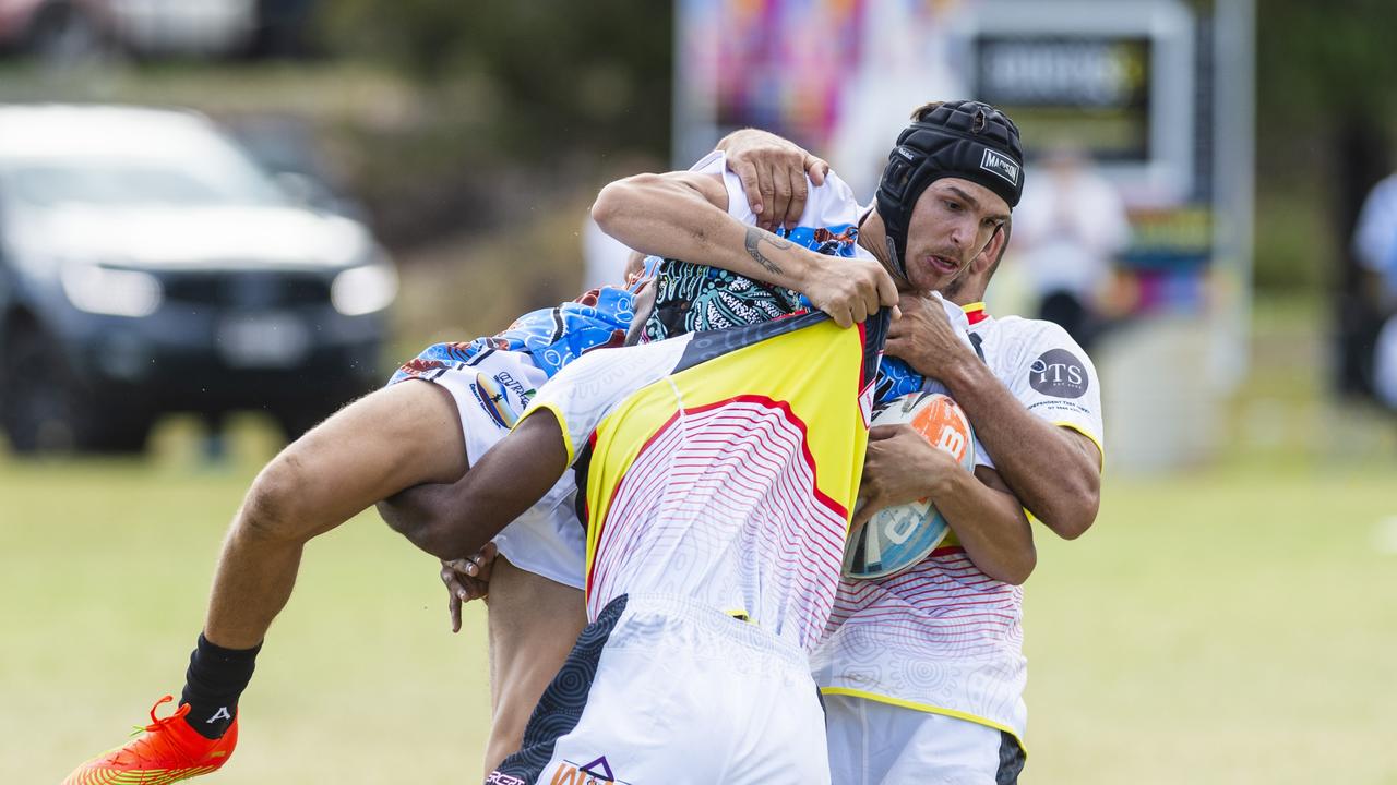 Chris Woodbridge of Coastal Blacks is lifted in a tackle by SEQ Magic players in the Warriors Reconciliation Knockout Carnival. Woodbridge has been a star for the Dalby Diehards this season. Picture: Kevin Farmer