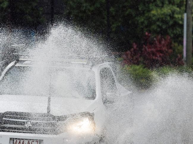 A car drives through flash flooding on Milton road on Tuesday. Picture Lachie Millard