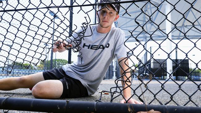 Head coach assistant of Baseline Tennis coaching academy Alwyn Musumeci shows where the thieves cut through the perimeter fence last year before smashing glass panel doors to enter the clubhouse and offices. Picture: Brendan Radke