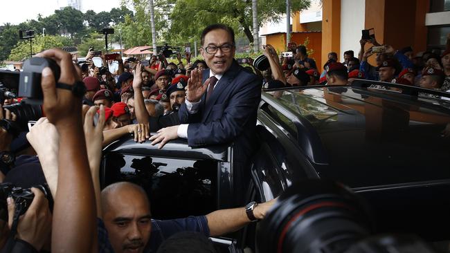 Malaysia's reformist icon Anwar Ibrahim, centre, waves to his supporters and journalists after leaving a hospital in Kuala Lumpur. Picture: AP