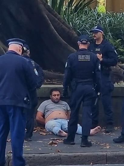 The man accused of stabbing a police officer seen on the ground after being arrested. Picture: TNV