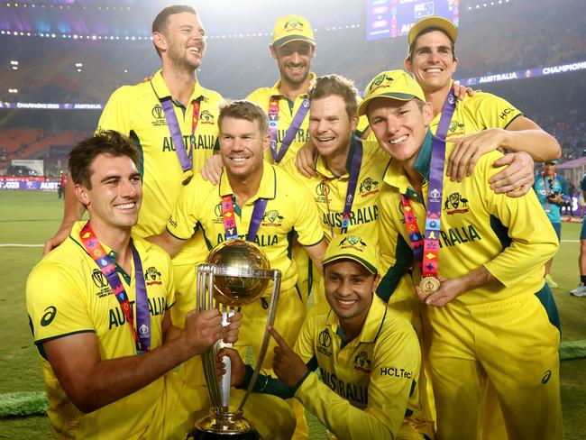 AHMEDABAD, INDIA - NOVEMBER 19: Sean Abbott, Adam Zampa, Pat Cummins, Steve Smith, David Warner, Mitchell Starc, Josh Hazlewood and Mitch Marsh of Australia pose with the ICC Men's Cricket World Cup following the ICC Men's Cricket World Cup India 2023 Final between India and Australia at Narendra Modi Stadium on November 19, 2023 in Ahmedabad, India. (Photo by Robert Cianflone/Getty Images)