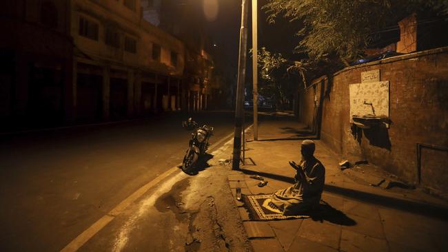 An Indian Muslim offers prayer on a street outside Jama Masjid on the first day of Ramadan during a nationwide lockdown to control the spread of coronavirus, in New Delhi, India.