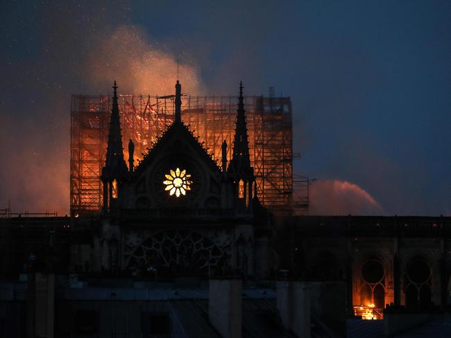 Firefighters douse flames rising from the roof at Notre-Dame Cathedral in Paris on April 15, 2019. (Photo by LUDOVIC MARIN / AFP)