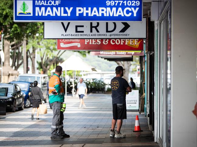 Customers waiting, 1.5m apart, outside Malouf Manly Pharmacy. Picture: Julian Andrews.