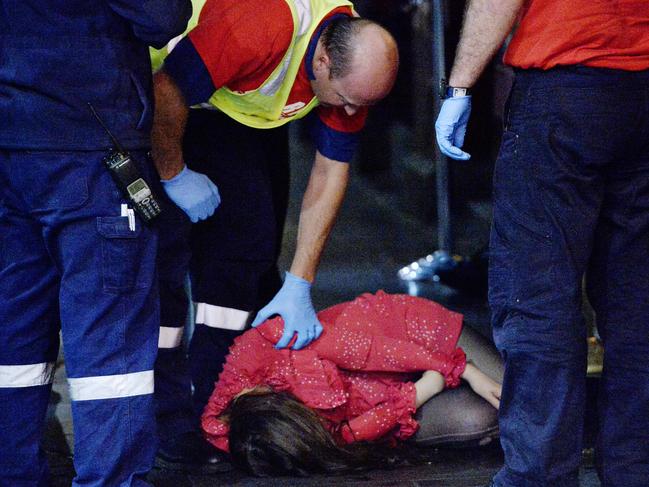 Friday night Melbourne CBD girls on the street. A young woman is tended to by paramedics outside the Young and Jackson Hotel on the corner of Swanston St and Flinders St. She is loaded into a car by the paramedics.